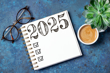 New year resolutions 2025 on desk. 2025 resolutions list with notebook, coffee cup on table. Goals, resolutions, plan, action, checklist concept. New Year 2025 template, copy space