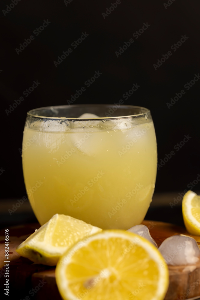 a close-up of lemons and a glass of lemon natural juice a close-up of lemons and a glass of lemon natural juice