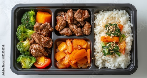 Delicious Lunch Meal With Seared Meat, Rice, and Vegetables in a Black Plasti...