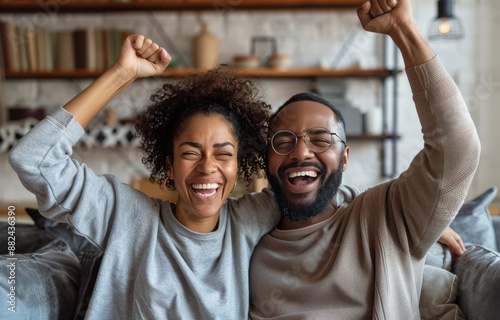 Excited Couple Celebrating a Victory on the Couch at Home