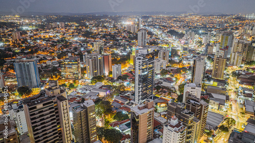 Vista aérea noturna do bairro Cambuí na cidade de Campinas, interior de São Paulo. Vários prédios residenciais e luzes da cidade com céu nublado.