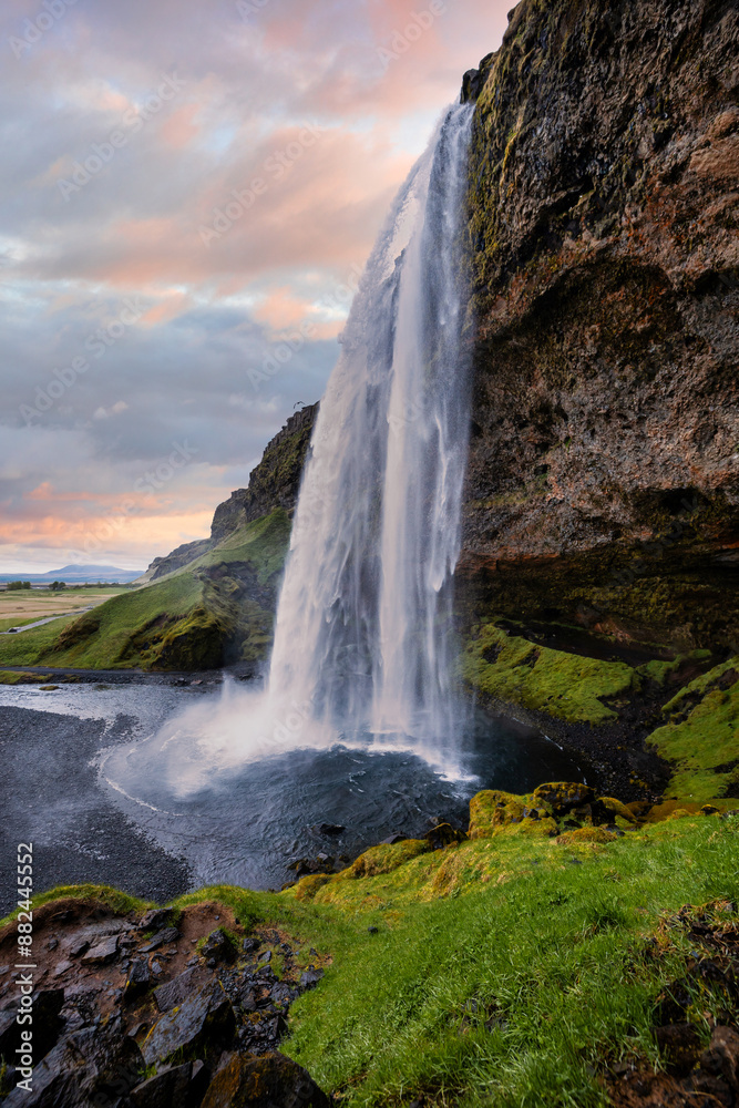 Fototapeta premium Majestic Seljalandsfoss Waterfall at Sunset in Iceland with Lush Green Landscape