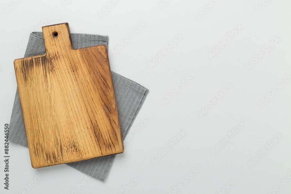 Fototapeta premium Cutting board with napkin on color background, top view