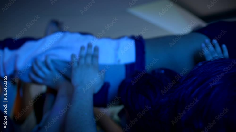 A group of people hold a girl above their heads  while dancing in a mosh pit at a wild house party