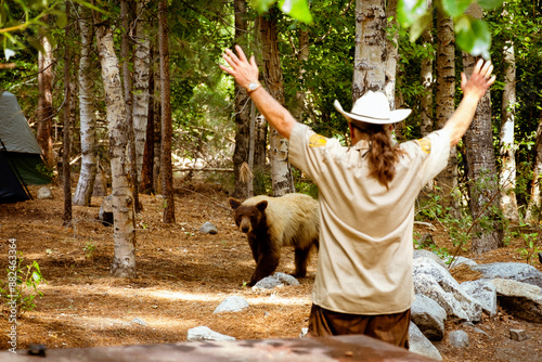 Εκτύπωση καμβά Ranger attempts to scare off black bear from campground