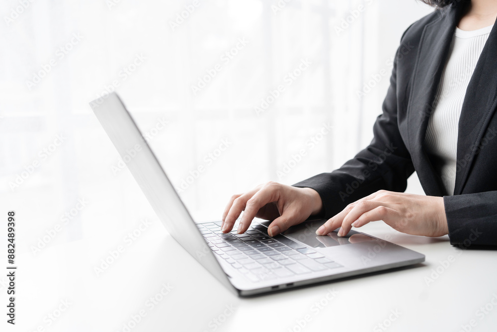 Focused businesswoman works on a laptop in a modern office, exuding confidence and professionalism. Bright natural light enhances the elegant atmosphere Focused businesswoman works on a laptop in a modern office, exuding confidence and professionalism. Bright natural light enhances the elegant atmosphere