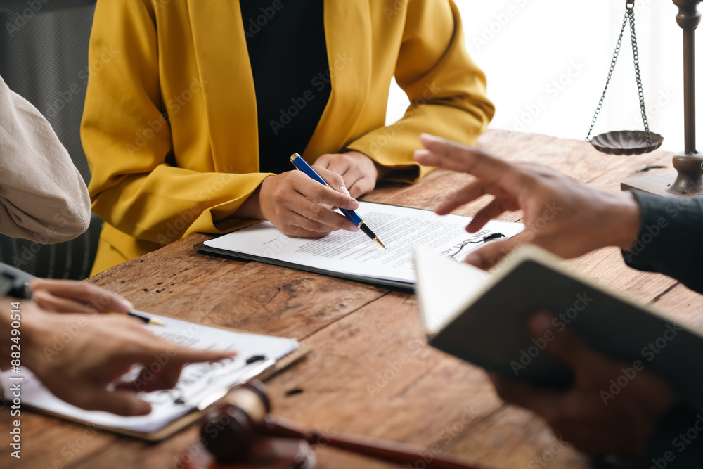 ©  NCST Studio - Lawyer is explaining contract details to client at a meeting in the office. They are discussing terms of agreement before signing