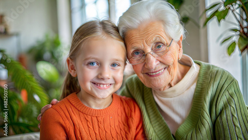 Portrait of a smiling grandmother and granddaughter looking at camera at home © NewFresh 