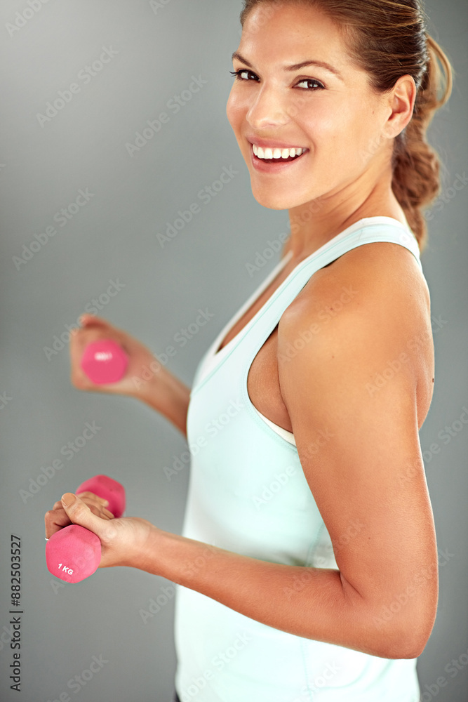 Portrait, dumbbells and woman with fitness, training and exercise on grey studio background. Face, happy person and athlete with equipment, workout and smile with wellness, energy and challenge Portrait, dumbbells and woman with fitness, training and exercise on grey studio background. Face, happy person and athlete with equipment, workout and smile with wellness, energy and challenge