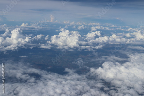 Aerial View of Urban Landscape with Airplane Wing Under Clear Blue Sky and Scattered Clouds