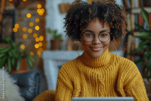 Black woman using laptop and mobile phone at white table with copy space Young smiling female in yellow sweater holding smartphone while working online Hands typing using digital devices
