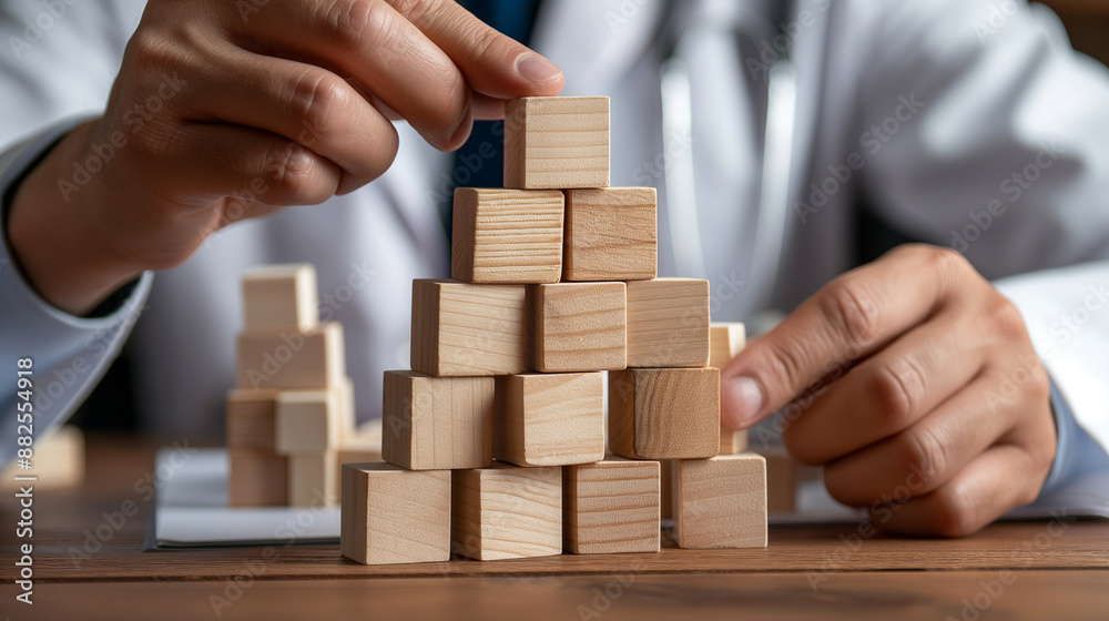 Doctor building pyramid with wooden blocks, medical concept, professional development, copy space Doctor building pyramid with wooden blocks, medical concept, professional development, copy space