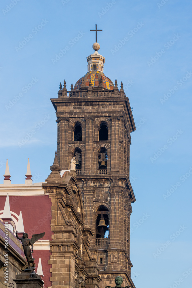 Fototapeta premium view of the tower of the metropolitan cathedral of Puebla framed with trees.