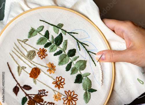 Woman's hands working on embroidery with thread and needle photo