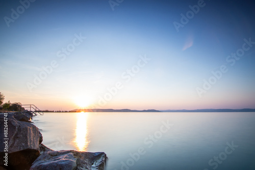 Landscape shot on the shore of a lake, nature in the sunset with a view to the horizon Siofok, Balaton, Hungary photo