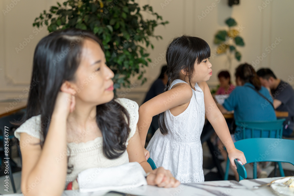 A twenty-something Chinese Malaysian woman and a six-year-old girl enjoying cake together at a stylish cafe in Selangor, Malaysia, on a sunny early summer afternoon. A twenty-something Chinese Malaysian woman and a six-year-old girl enjoying cake together at a stylish cafe in Selangor, Malaysia, on a sunny early summer afternoon.