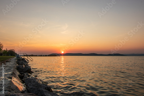 Landscape shot on the shore of a lake, nature in the sunset with a view to the horizon Siofok, Balaton, Hungary photo