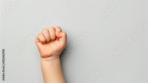 A clenched fist rises against a plain grey backdrop