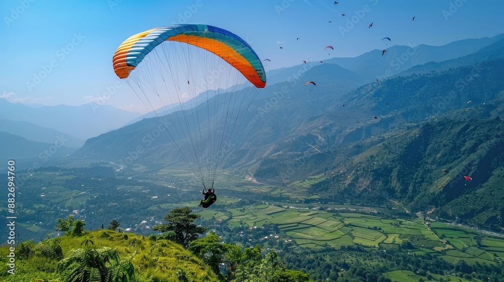 A person paragliding over beautiful mountain scenery. A person paragliding over beautiful mountain scenery.
