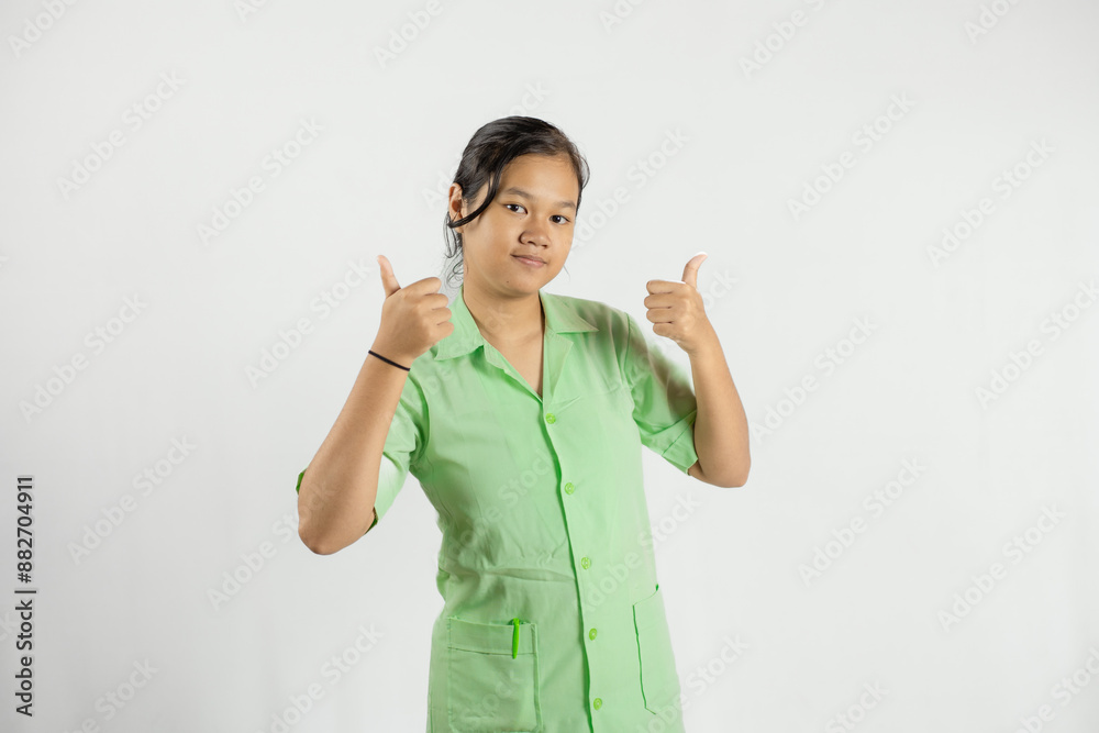 A young Asian female nurse gives a thumbs up to the camera, the concept of health care and dedicated work, isolated against a white background.
A young Asian female nurse gives a thumbs up to the camera, the concept of health care and dedicated work, isolated against a white background.