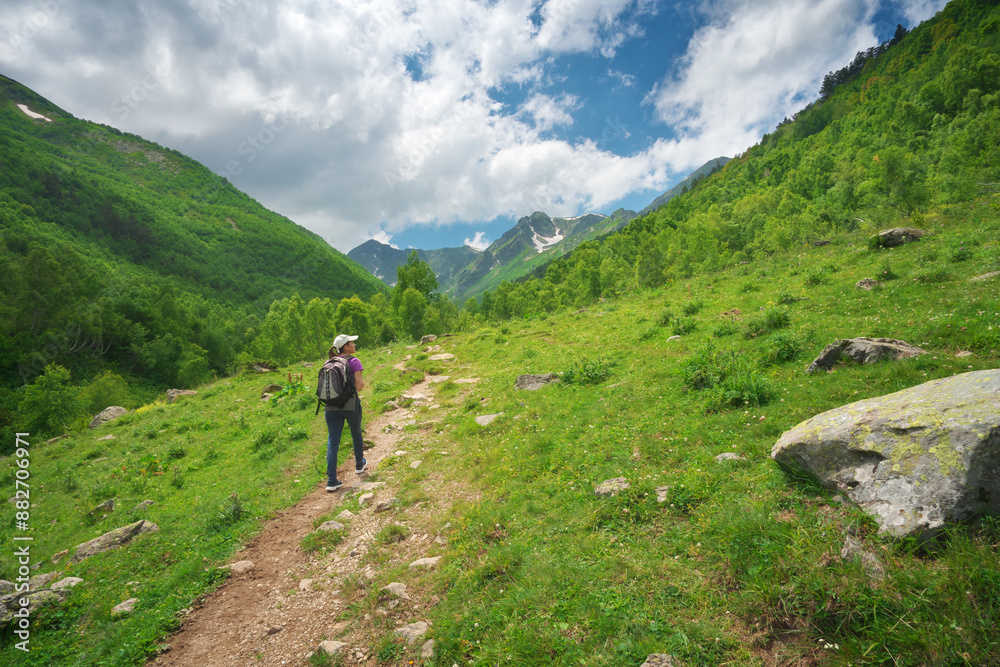 Young woman walking in mountain valley. Young woman walking in mountain valley.