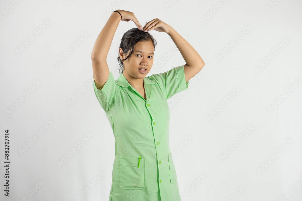 Young Asian female nurse making love shapes with her hands, gesture of love, dedicated work, concept of health care, isolated white background.
