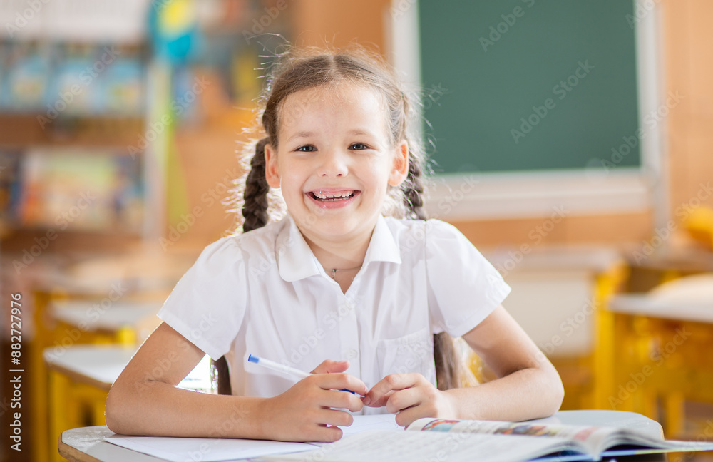 Back to school, girl sitting at a desk in the classroom. A schoolgirl sits at her desk and laughs joyfully; the child has school supplies on the table. The girl is dressed in a school uniform.
Back to school, girl sitting at a desk in the classroom. A schoolgirl sits at her desk and laughs joyfully; the child has school supplies on the table. The girl is dressed in a school uniform.