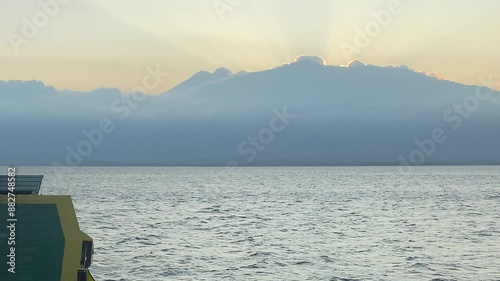 sunrise in the middle of the sea behind the mountains