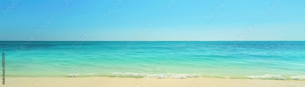 Clear blue ocean water gently laps at a sandy beach under a bright blue sky. Clear blue ocean water gently laps at a sandy beach under a bright blue sky.