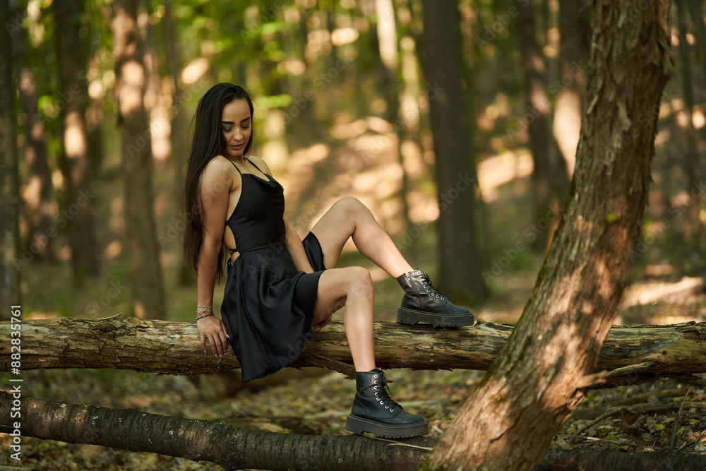 Young woman in mini black dress in the forest Young woman in mini black dress in the forest