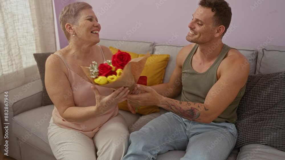 Woman and man sharing a joyful moment with flowers in a cozy home living room depicting family love and togetherness