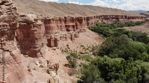 Majestic red rocks of the Temirlik Canyon in Kazakhstan. Sandy rocks eroding due to erosion. Flying over the canyon photo