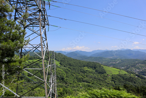 Electric transmission lines against the background of blue sky and mountains. Electricity.