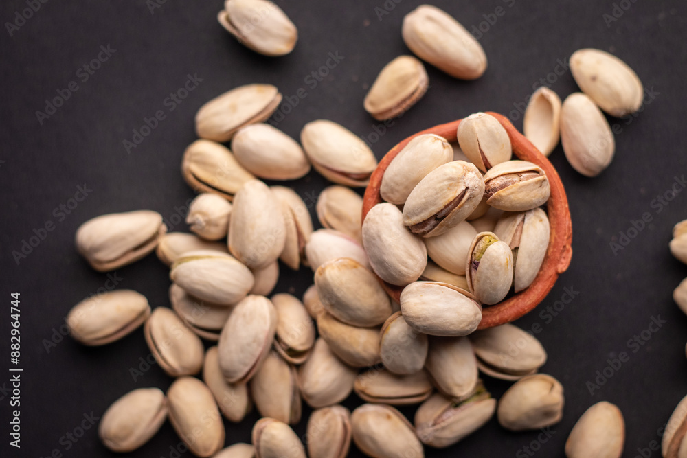 Pistachio nuts kept in a clay pot on a dark grey background Pistachio nuts kept in a clay pot on a dark grey background