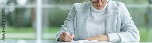 A woman is writing in a notebook