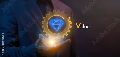 Growth value, increasing value added to business product and service. Business and finance growth concept. Businessman showing glowing neon line of daimond inside cogwheel icon on virtual screen.