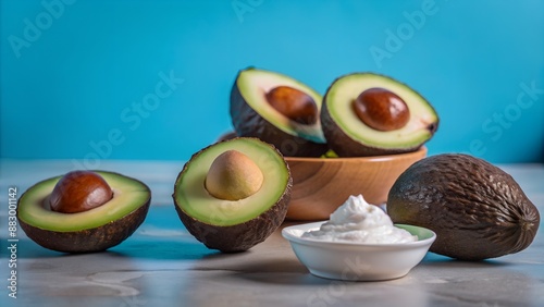 Halved avocados and bowl with avocado halves and creamy spread photo