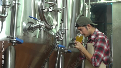 The Asian male owner is checking the beer quality over a glass of craft beer. Ideas for making craft beer photo