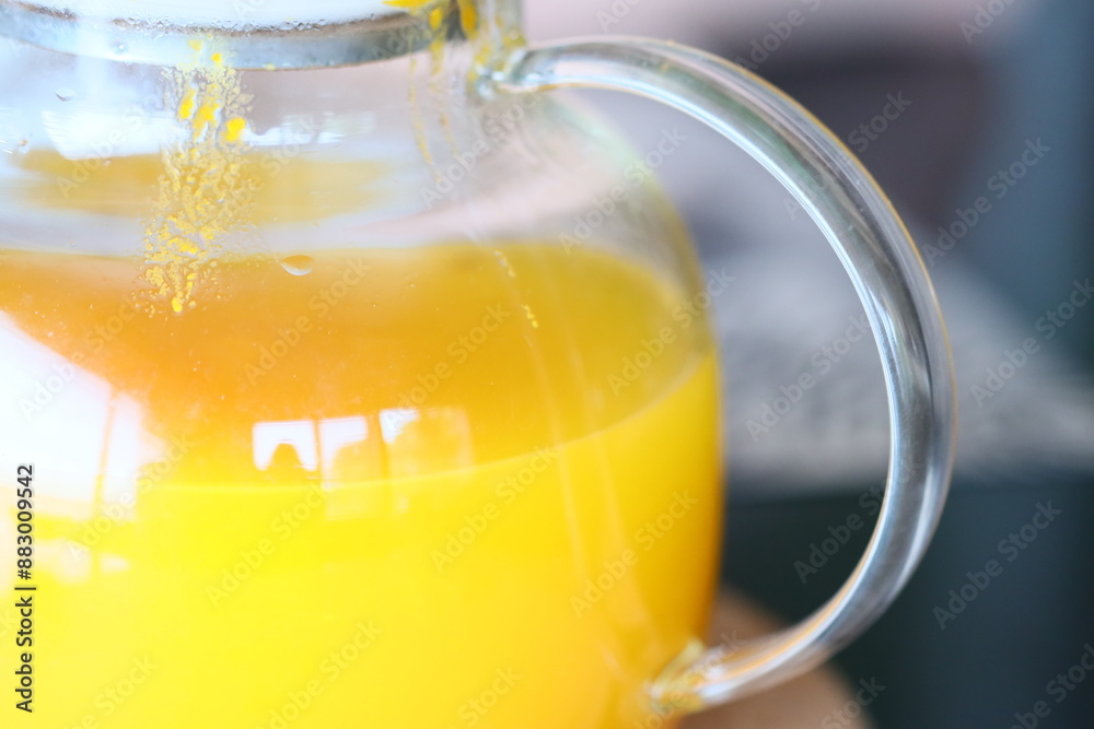 A person holding a pitcher of freshly squeezed orange juice, perfect for a morning pick-me-up or a refreshing drink at a summer gathering. A person holding a pitcher of freshly squeezed orange juice, perfect for a morning pick-me-up or a refreshing drink at a summer gathering.