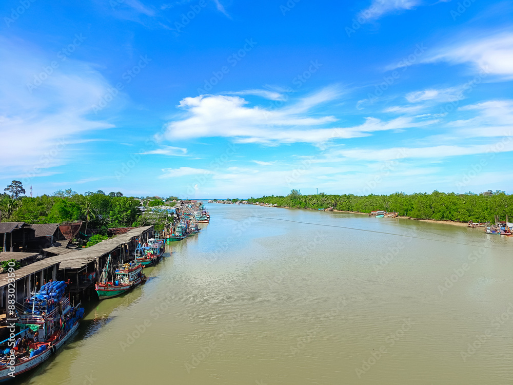 Fototapeta premium Blue sky background with clouds. Bright sky and clouds of the day. fishing village Located along the river, community and rural way of life. Long holiday, background for relaxation mood Relaxation.