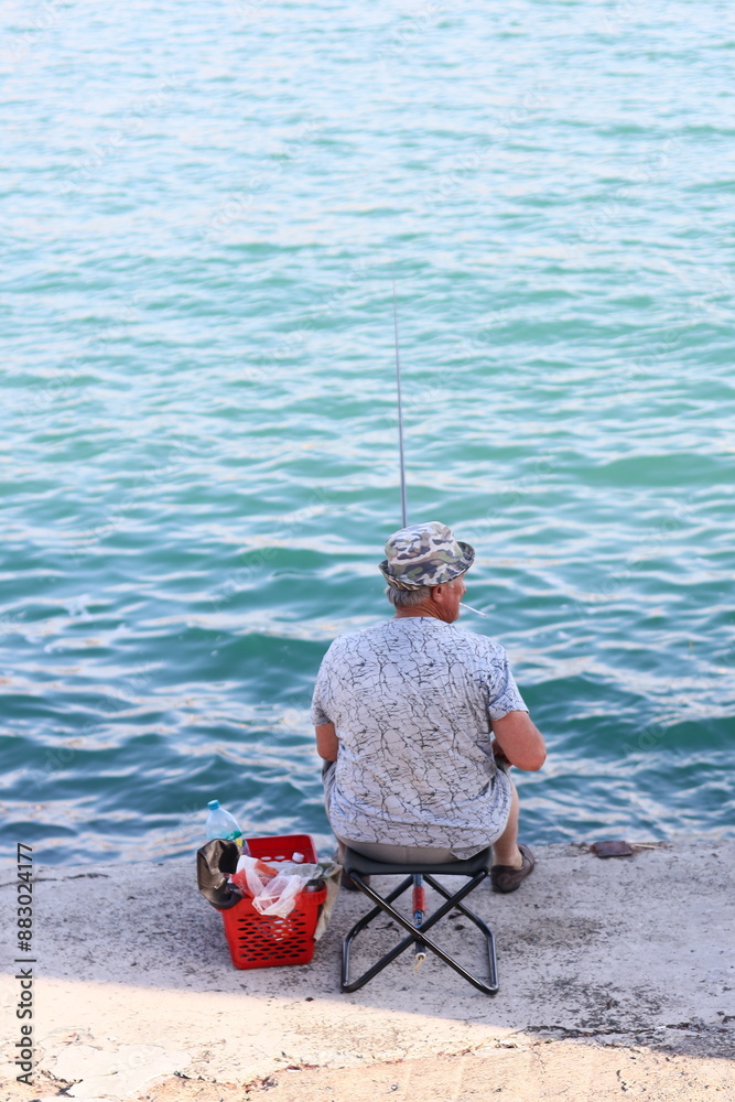 A person relaxing on a sandy beach with the ocean in the background.