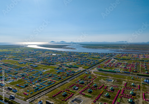 Aerial and afternoon view of road and camping tents on reclaimed land of Saemangeum Tide Embankment against sea for 2023 Saemangeum World Scout near Buan-gun, South Korea
 photo