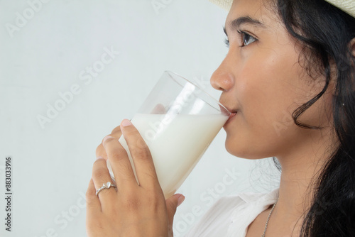 close-up view of young woman drinking a glass of soy milk, cow's milk with calcium protein, healthy lifestyle, side view of young woman