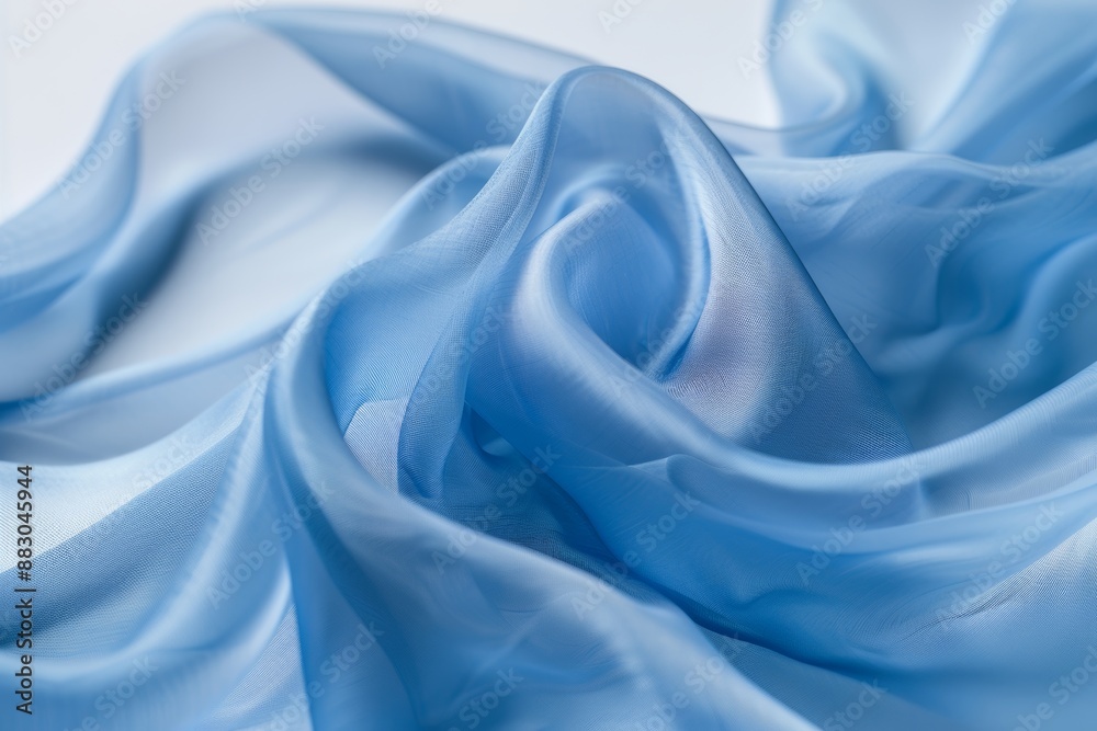 Obraz premium Abstract background wallpaper, close-up of blue fabric, smooth and flowing in the wind, against a white background. The focus is on capturing the texture and softness of the material. curves folds