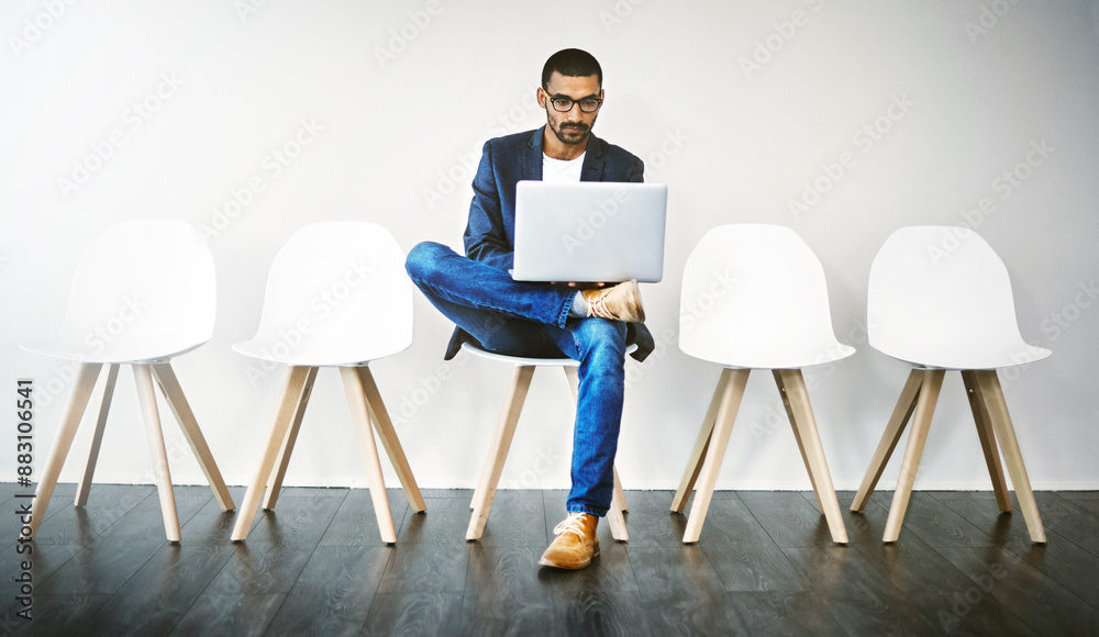 Fototapeta premium Waiting room, business man and laptop for interview, planning and research questions for hr recruitment. Wall background, male candidate and digital for information, opportunity and reading portfolio
