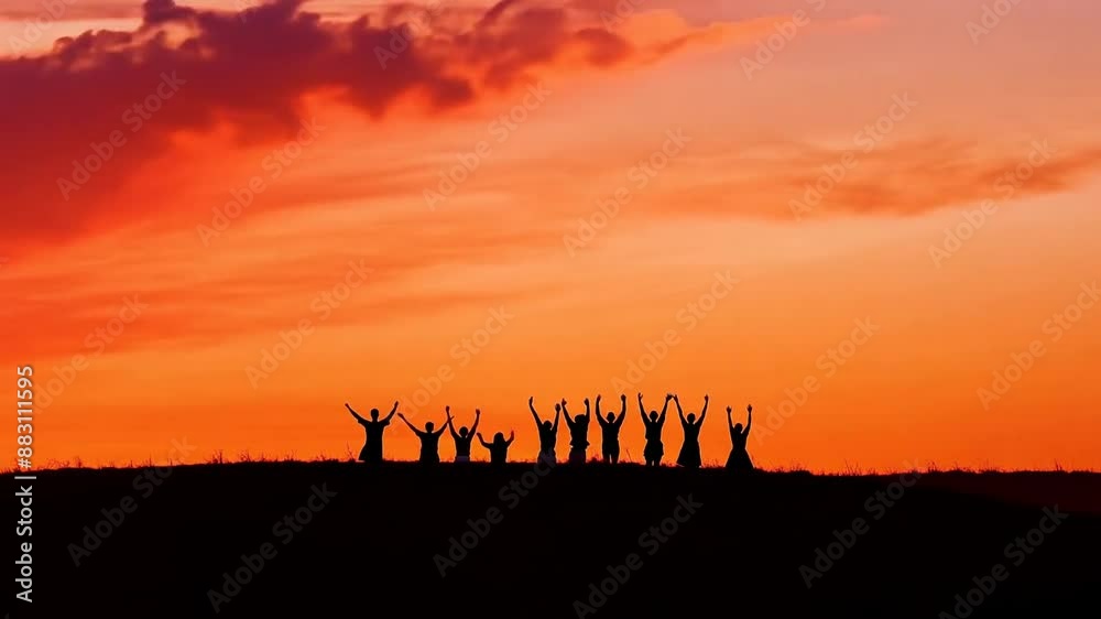 Silhouetted friends enjoying sunset on hilltop