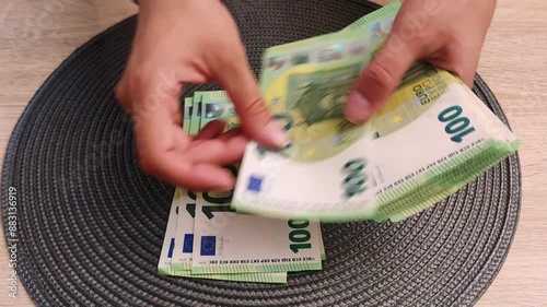 View of female hands counting euro banknotes on a dark background