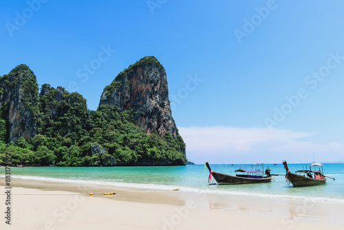 Typical long tail boat in Island in Krabi Thailand. Ao Phra Nang Beach wooden longtail boat on Railay Peninsula in front of Limestone karst rocks, close to Ao Nang, Krabi province, Thailand