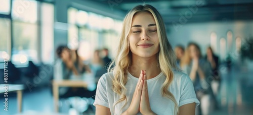 Beautiful blonde woman with folded hands among her colleagues during a team meeting. © grigoryepremyan