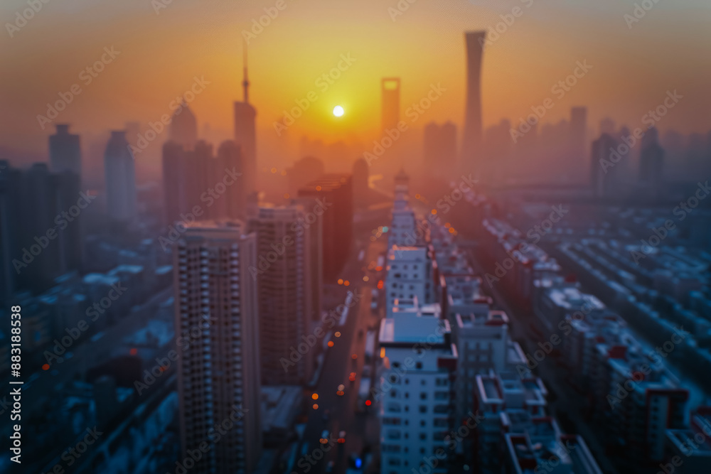Fototapeta premium A multi-story building silhouetted against a stunning sunset, with warm orange and pink hues lighting up the sky. The scene captures the calm beauty of the evening.